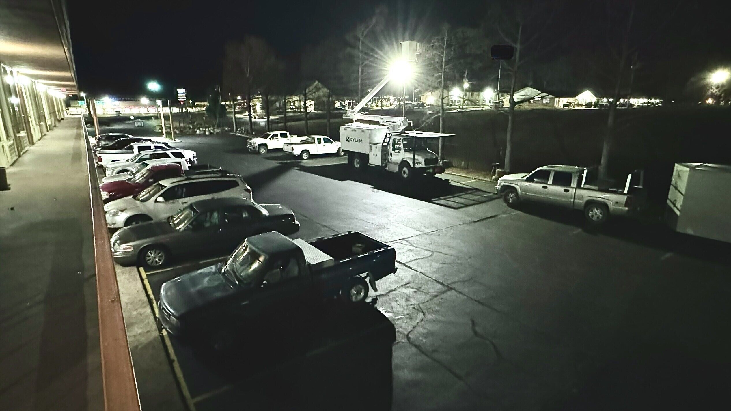A parking lot with several cars and a utility truck.