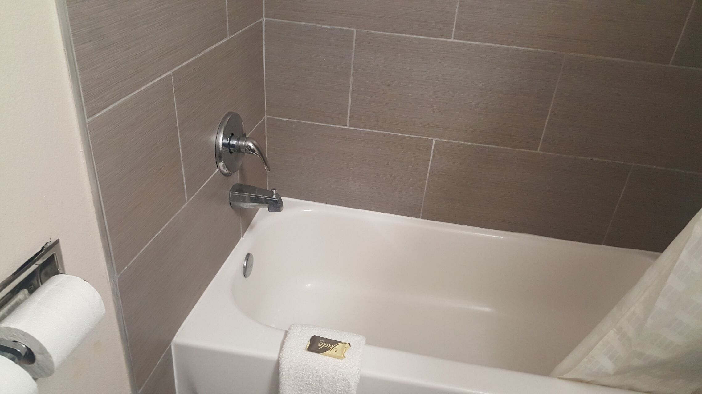 A bathroom with a bathtub, a toilet, and a towel rack.