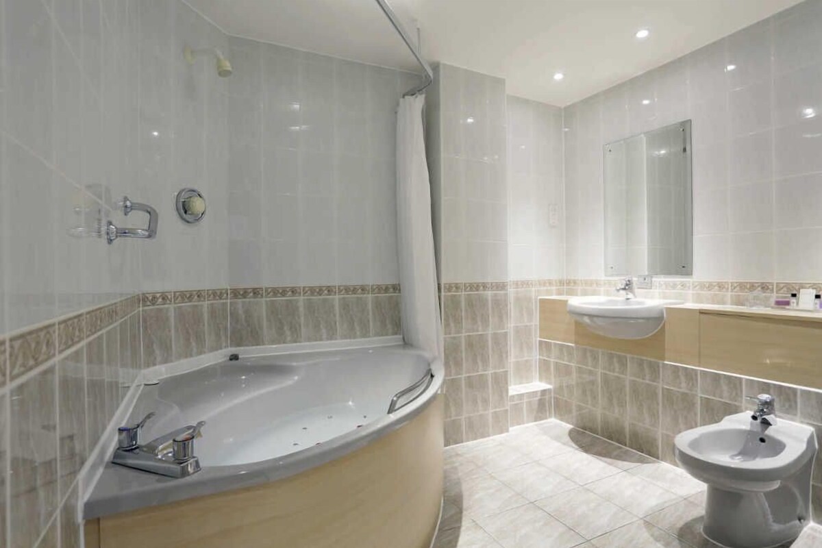 A modern bathroom with a freestanding bathtub, a sink, and a bidet.