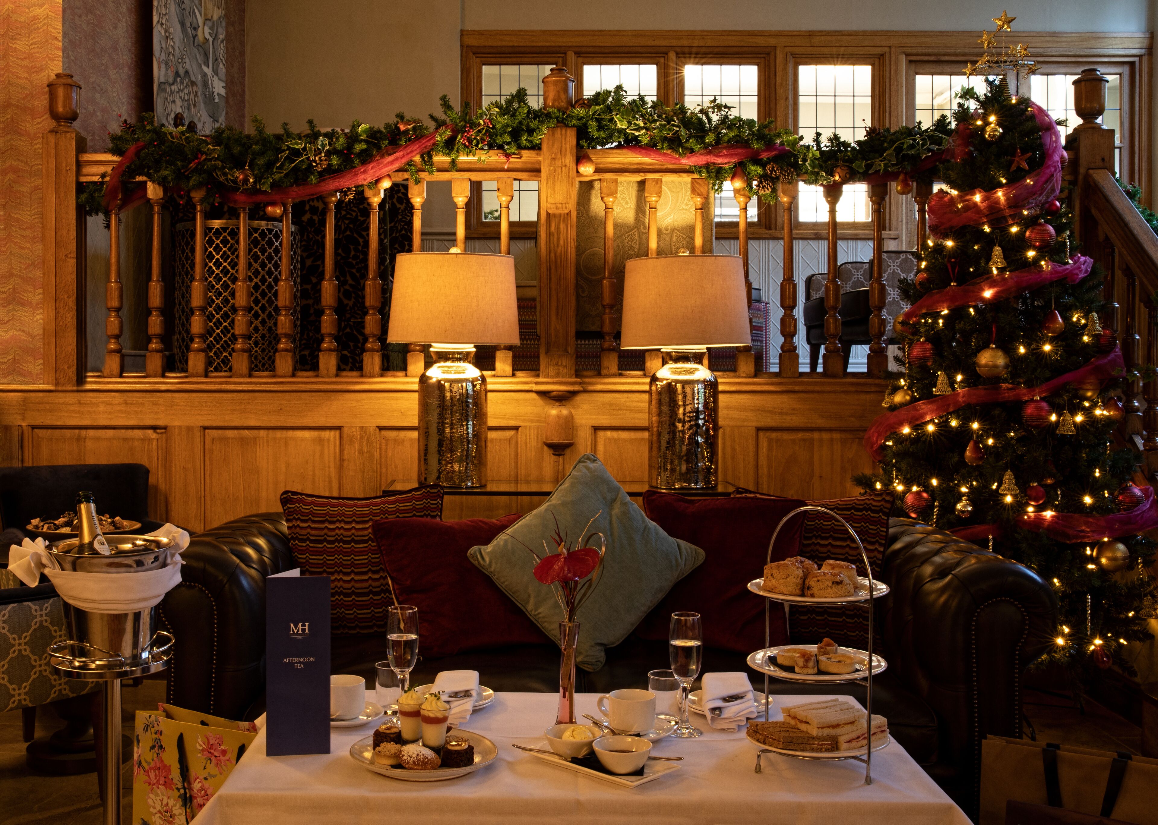 A cozy dining area with a Christmas tree, a fireplace, and a view of the cityscape.