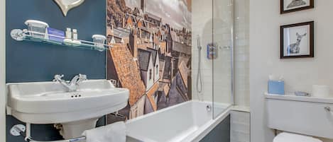 Un baño moderno con una bañera grande, un lavabo y un inodoro.