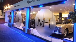 A Wine Press fine dining establishment with a classic car displayed outside.