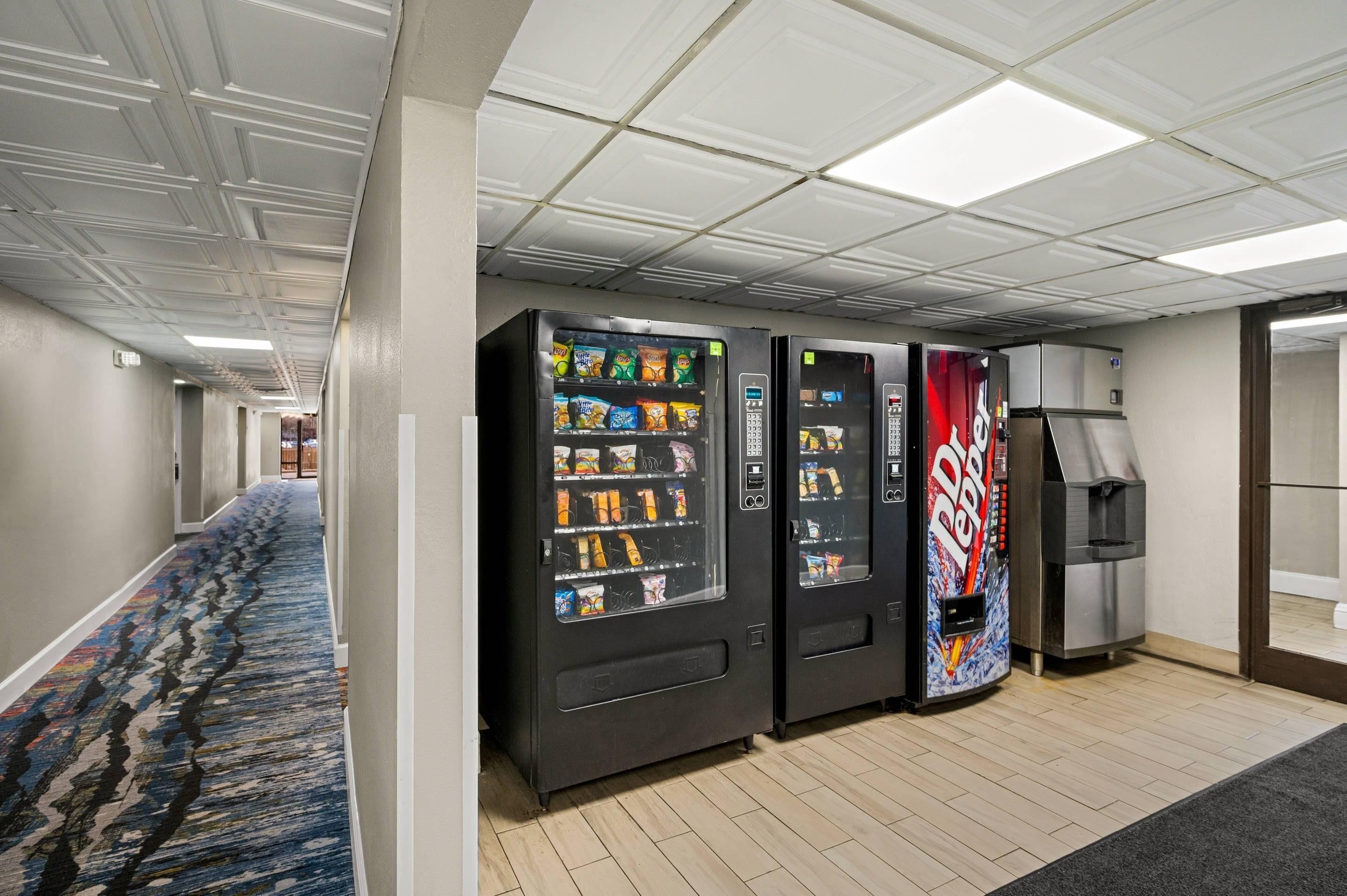 A hallway with vending machines and a refrigerator.