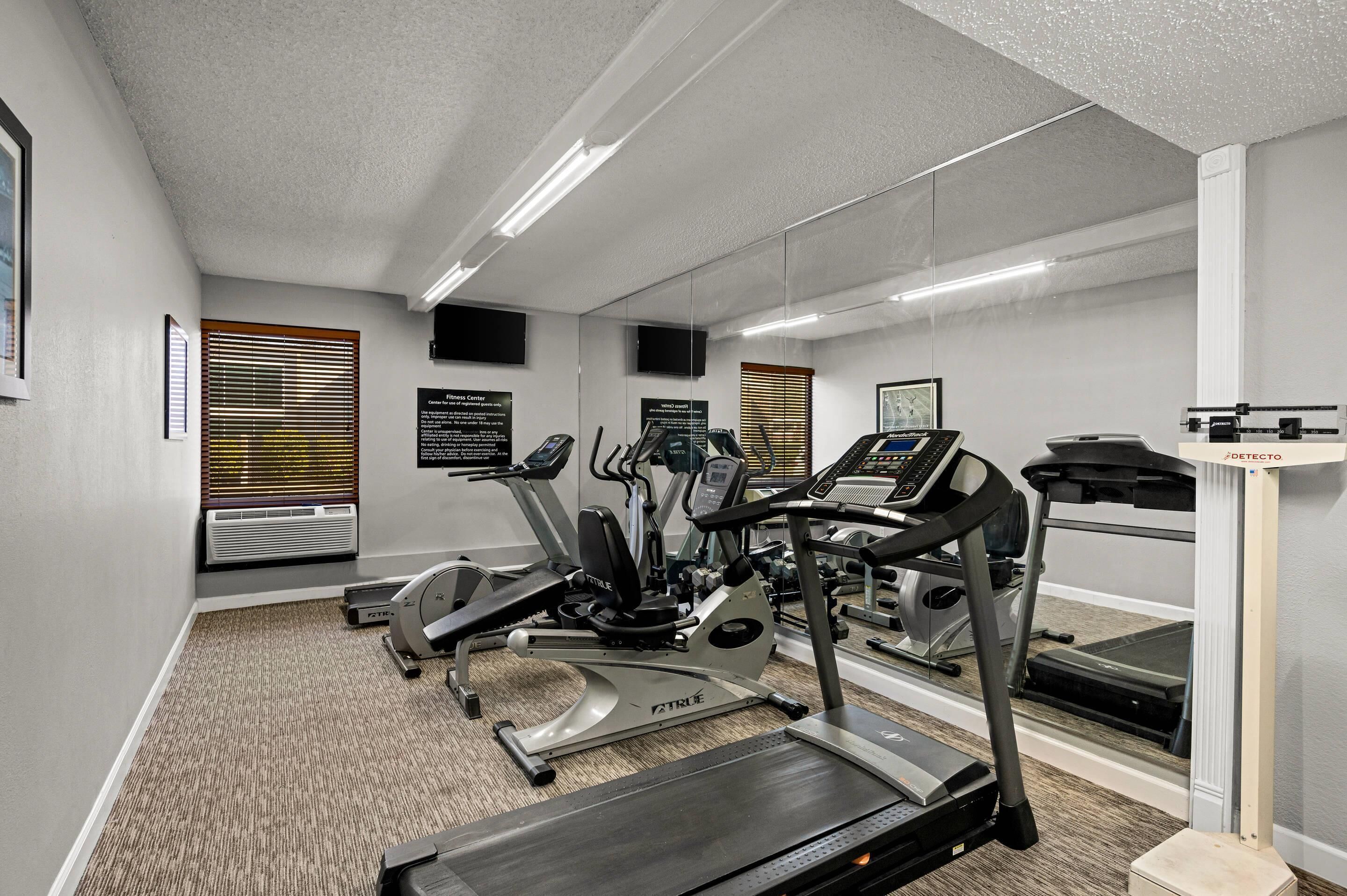 A fitness center with treadmills, elliptical machines, and a stationary bike.