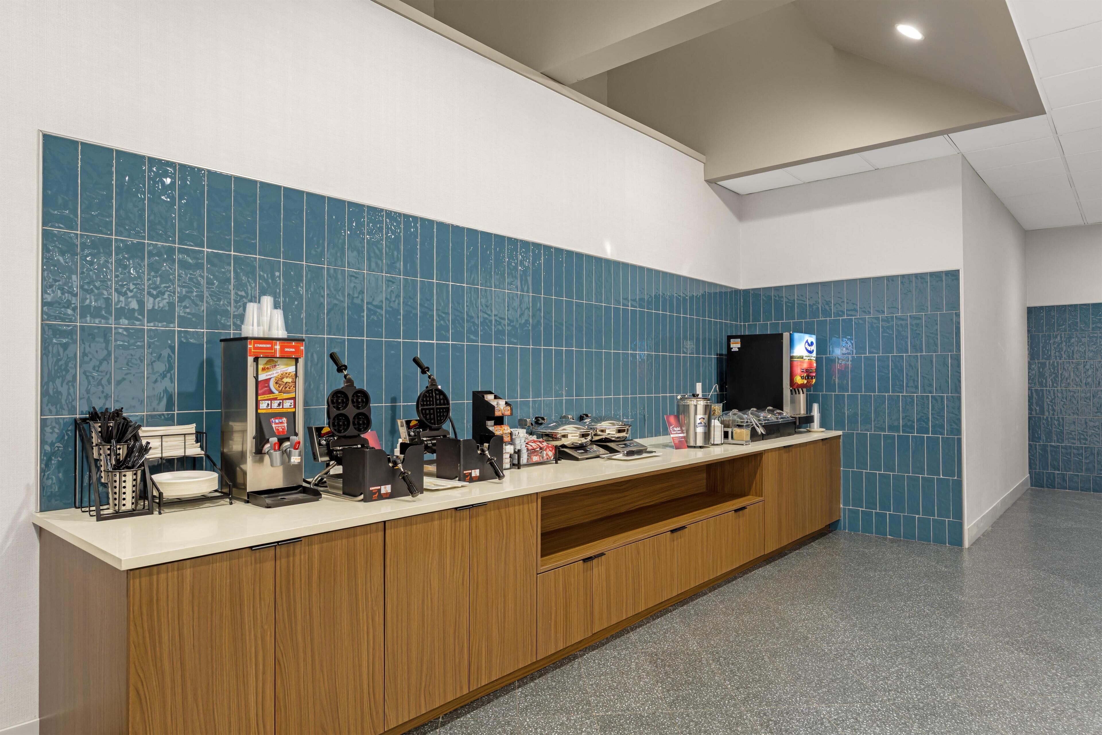 A reception area with a counter, coffee machine, and a digital screen.