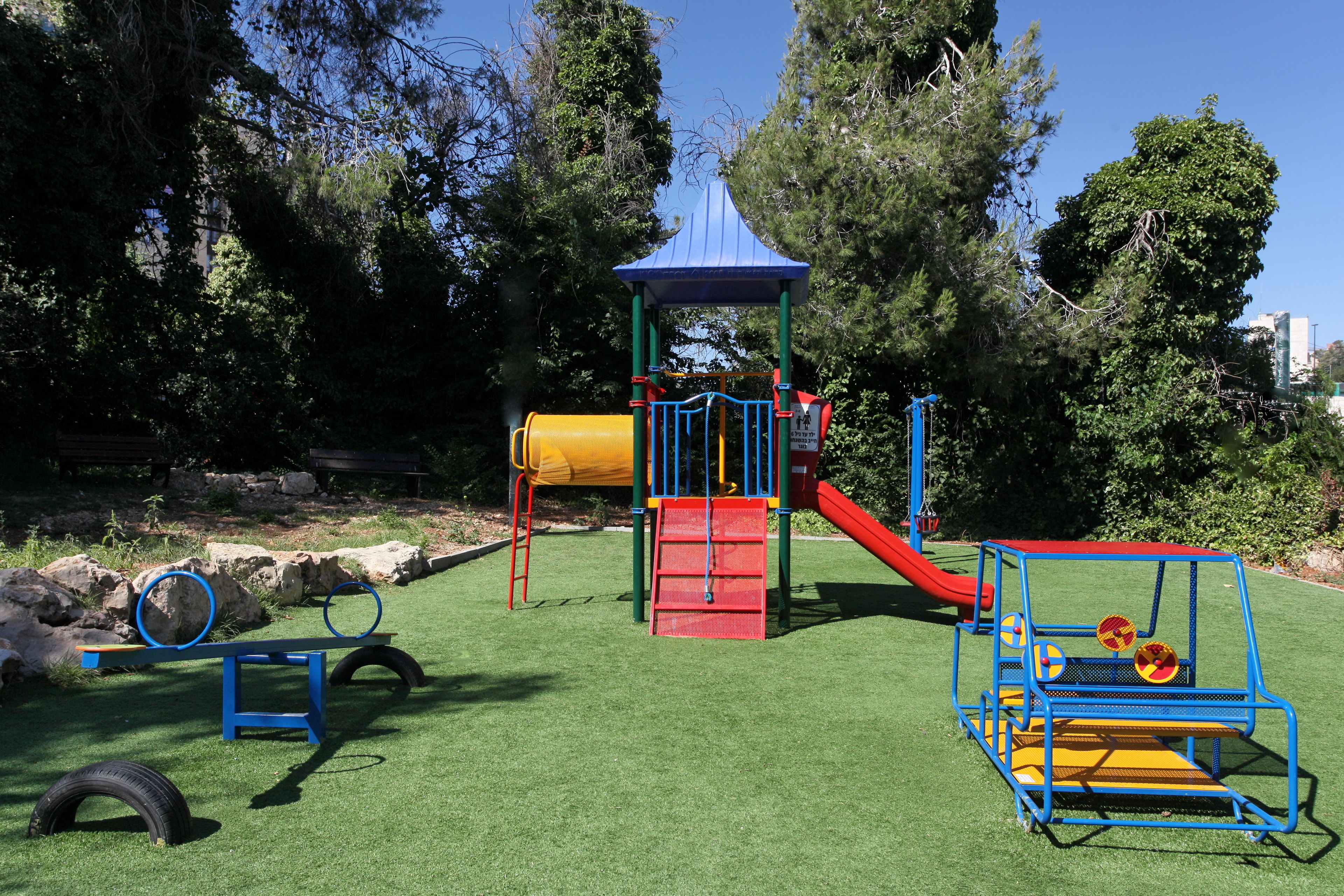 A playground with a slide, climbing structures, and tire swings.