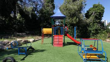 A playground with a slide, climbing structures, and tire swings.
