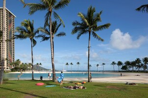Ein Hotel direkt am Strand mit Palmen, einem Pool und einem Strand im Hintergrund.