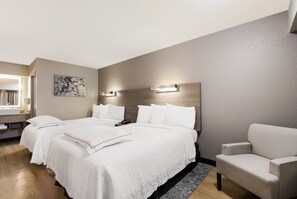 A hotel room with two beds, a sofa, a painting, and a window with curtains. - Red Roof Inn PLUS+ Chicago - Naperville (Naperville)