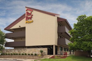 A Red Roof Plus hotel with a modern architectural design, featuring a stone facade and a flat roof. - Red Roof Inn PLUS+ Chicago - Naperville (Naperville)