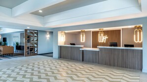 A modern reception area with a herringbone patterned floor, a reception desk, and a wooden partition. - Holiday Inn Dublin-Pleasanton by IHG (Dublin)