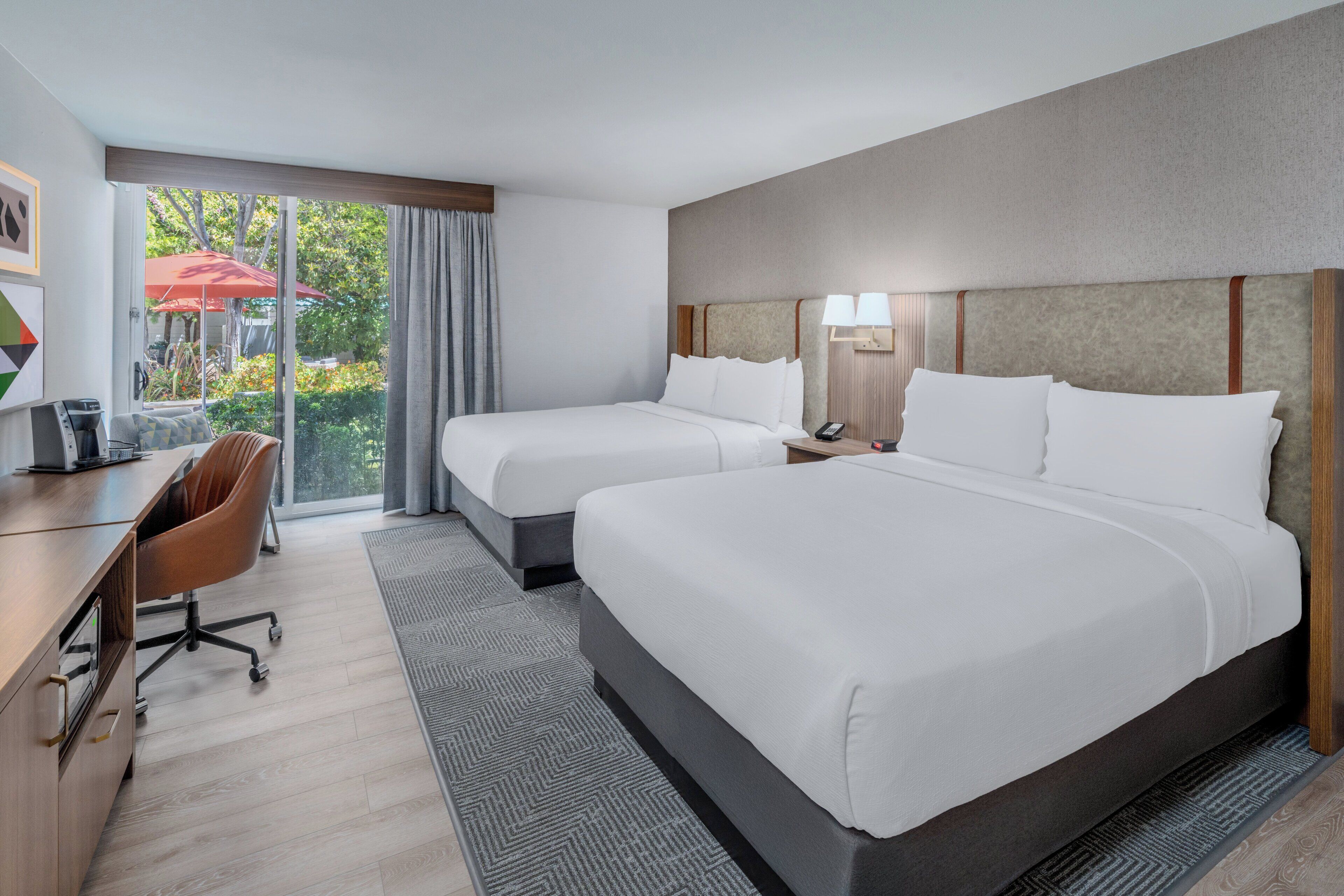 Una habitación de hotel con dos camas, un escritorio y una silla.