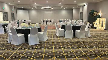 A conference room with tables and chairs, a patterned carpet, and a large illuminated number 40 sign.
