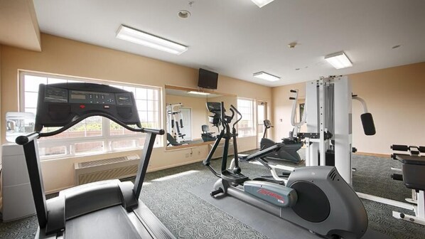 A gym with treadmills, elliptical machines, and weight equipment.