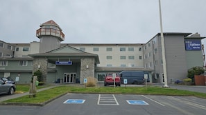 A building with a registration sign, a parking lot with handicapped parking spaces, and a sign for Lighthouse Suites Inn.