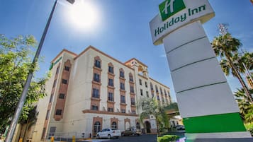 A Holiday Inn hotel with a large building, a parking lot, and a street lamp.