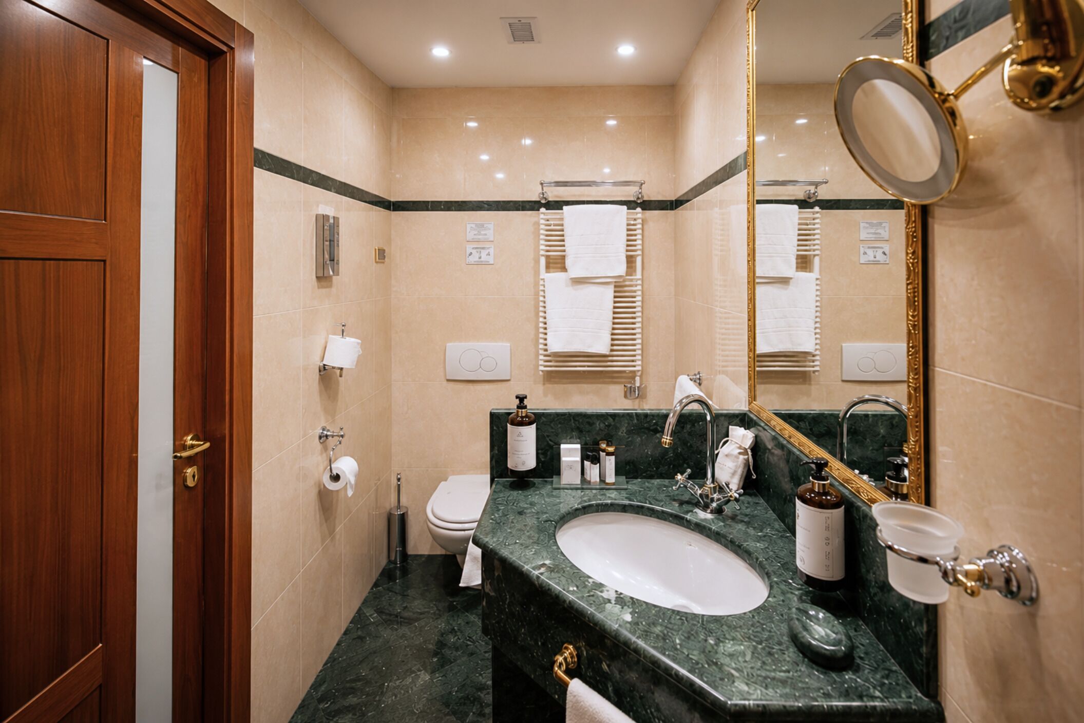 Un bagno con una porta in legno, un lavandino, un water e uno specchio.