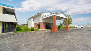 A hotel with a covered entrance, a parking lot, and a building with a blue and white facade. - Loyalty Inn Maryville (Maryville)
