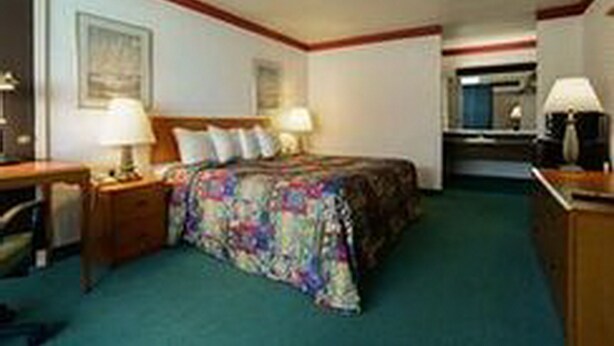 A hotel room with a bed, bedside tables, a desk, and a chair. - Loyalty Inn Maryville (Maryville)