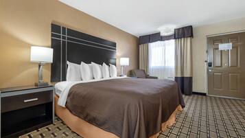 Une chambre d’hôtel avec un grand lit, des tables de chevet, un bureau et une chaise.