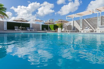 Piscine extérieure, parasols de plage, chaises longues