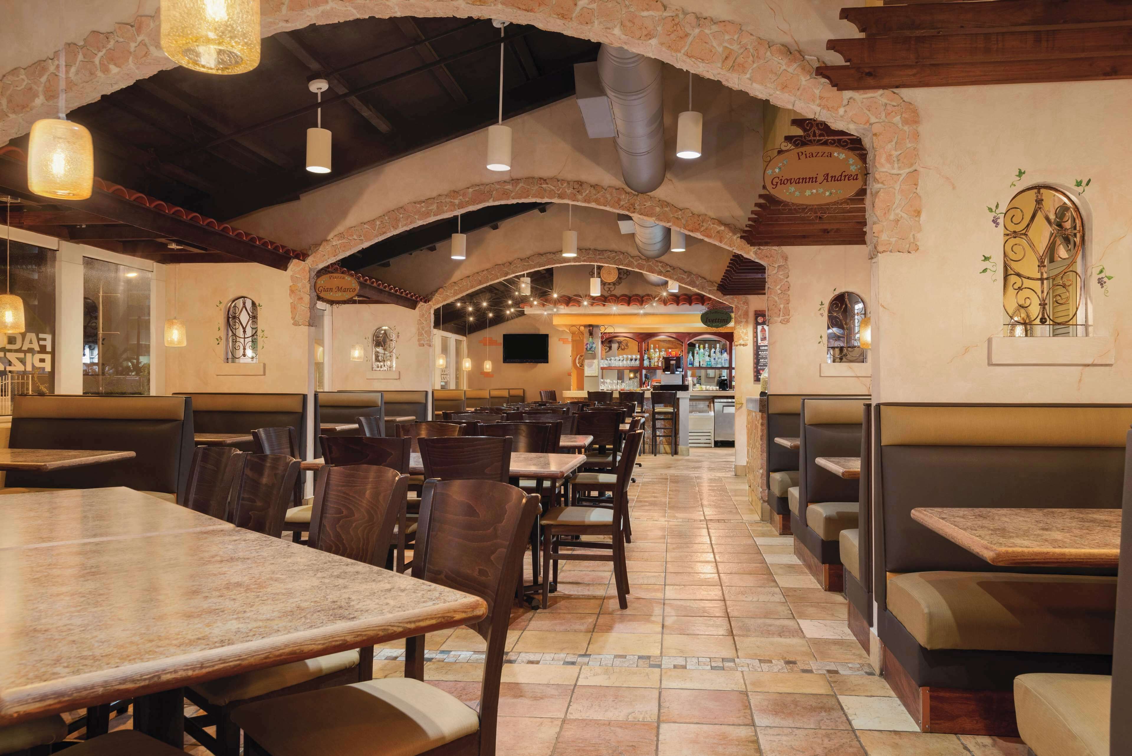 Un restaurante con arcos de piedra, mesas y cabinas de madera.