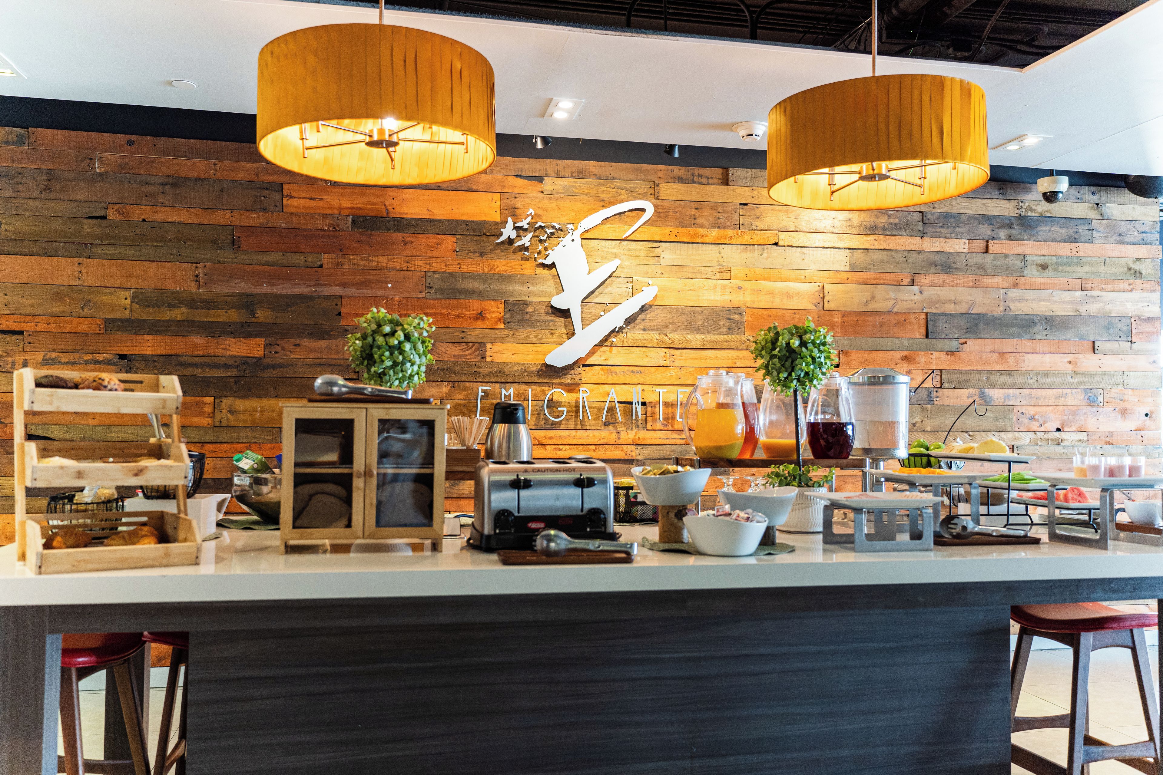 A breakfast bar with wooden paneling, a coffee machine, and various breakfast items.
