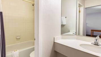 A bathroom with a bathtub, toilet, and sink.