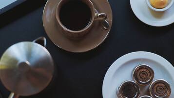 Una bandeja con una taza de café, un plato de pasteles y un libro.