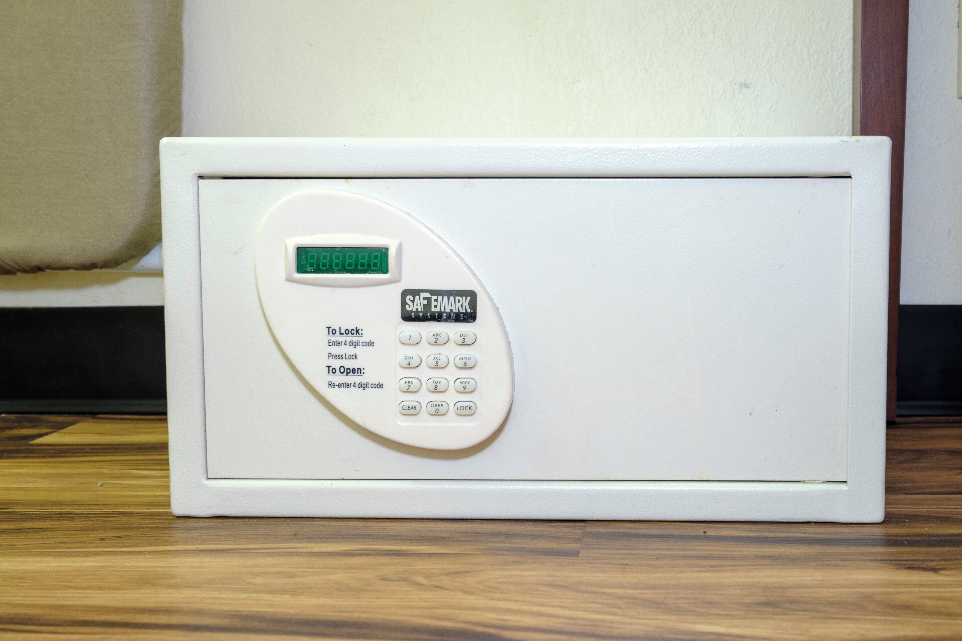 A white safesystem with a digital display and keypad.