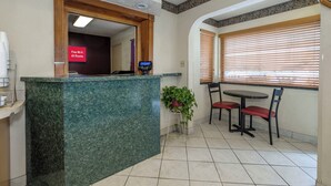 A reception area with a marble counter, a digital payment terminal, and a sign indicating free Wi-Fi in all rooms. - Red Roof Inn Edgewood (Edgewood)