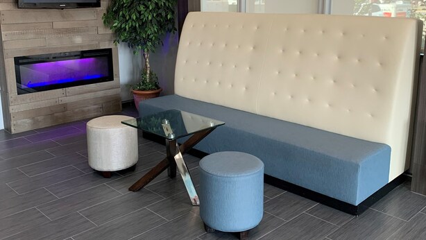 A modern living room with a sofa, a TV, a plant, and a glass coffee table. - Howard Johnson by Wyndham Oklahoma City Airport/ Fairgrounds (Oklahoma City)