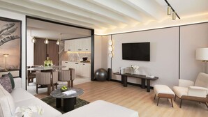 A modern living room with a sofa, a coffee table, and a TV mounted on the wall.