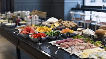 Un bufé con diversos alimentos y utensilios.