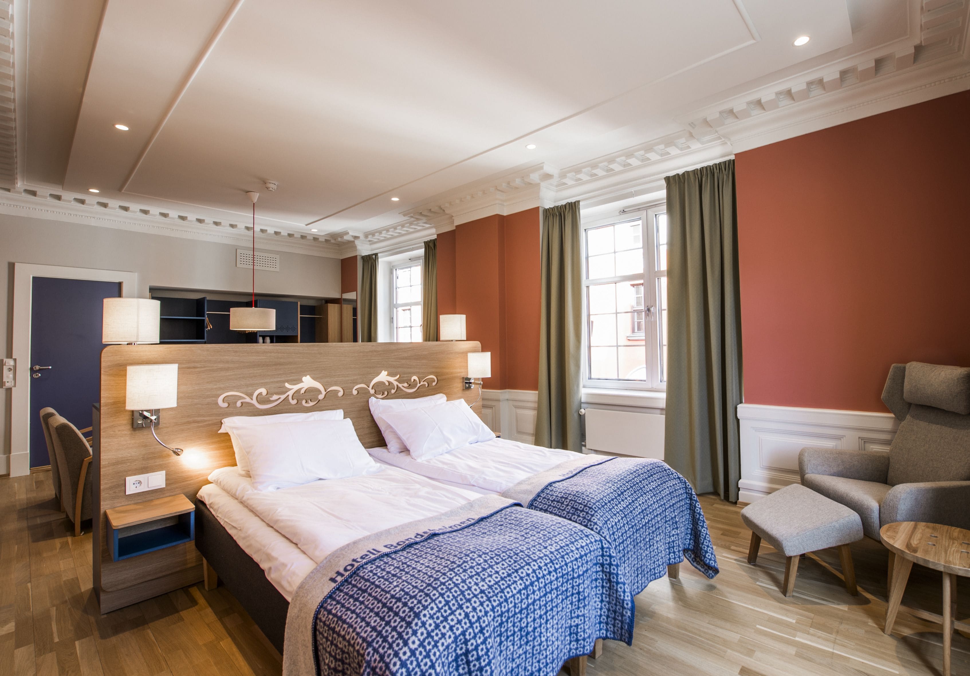 Senger med overmadrass, safe på rommet, skrivebord og blendingsgardiner