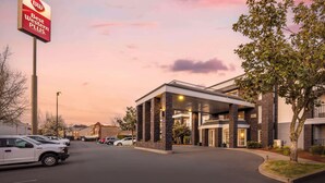 A Best Western Plus hotel with a modern design, a covered parking area, and a clear sky at dusk. - Best Western Plus Grand Manor Inn (Springfield)