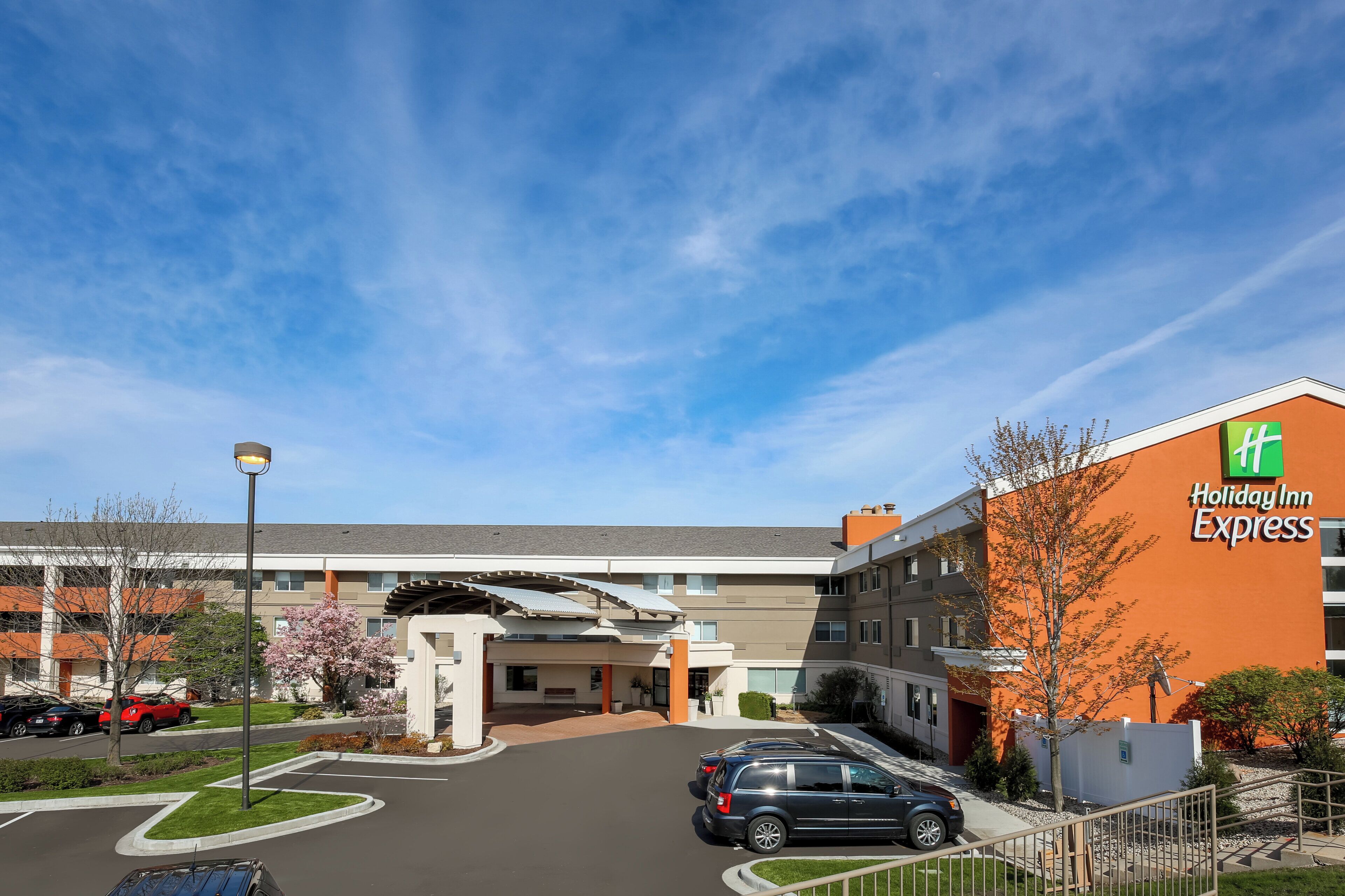 A Holiday Inn Express building with a parking lot and a clear sky.
