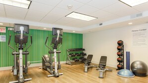 Un centre de remise en forme équipé de machines de cardio, d’haltères et de ballons d’exercice.
