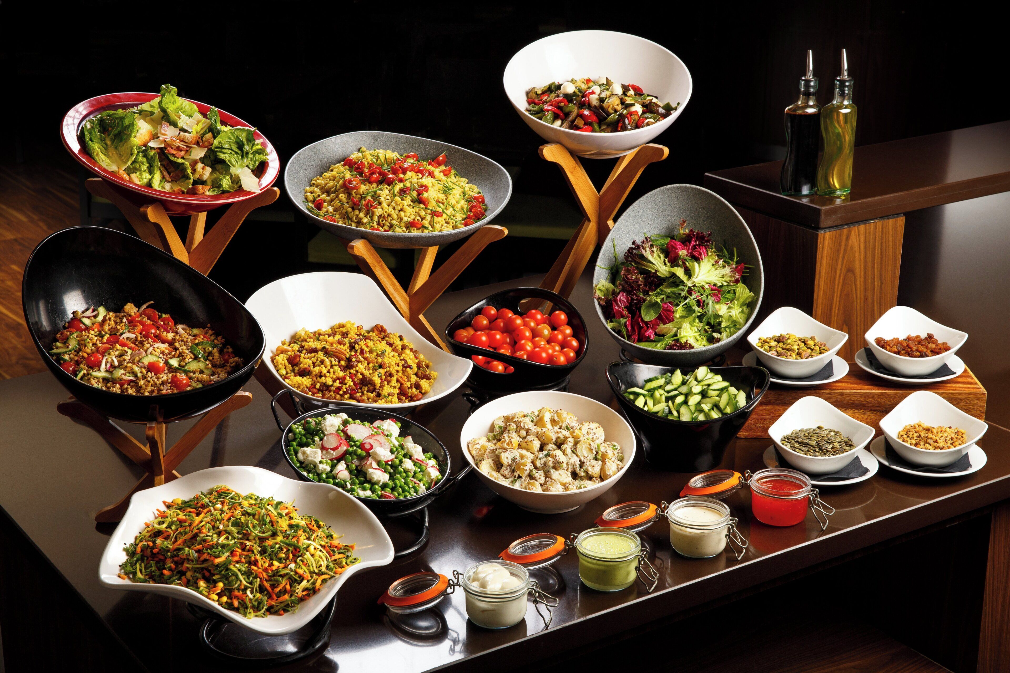 A variety of dishes on a buffet table with multiple serving bowls and small jars of condiments.