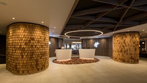 Un hall d’entrée doté de deux grandes colonnes cylindriques, d’un comptoir de réception et d’un sol à motifs.