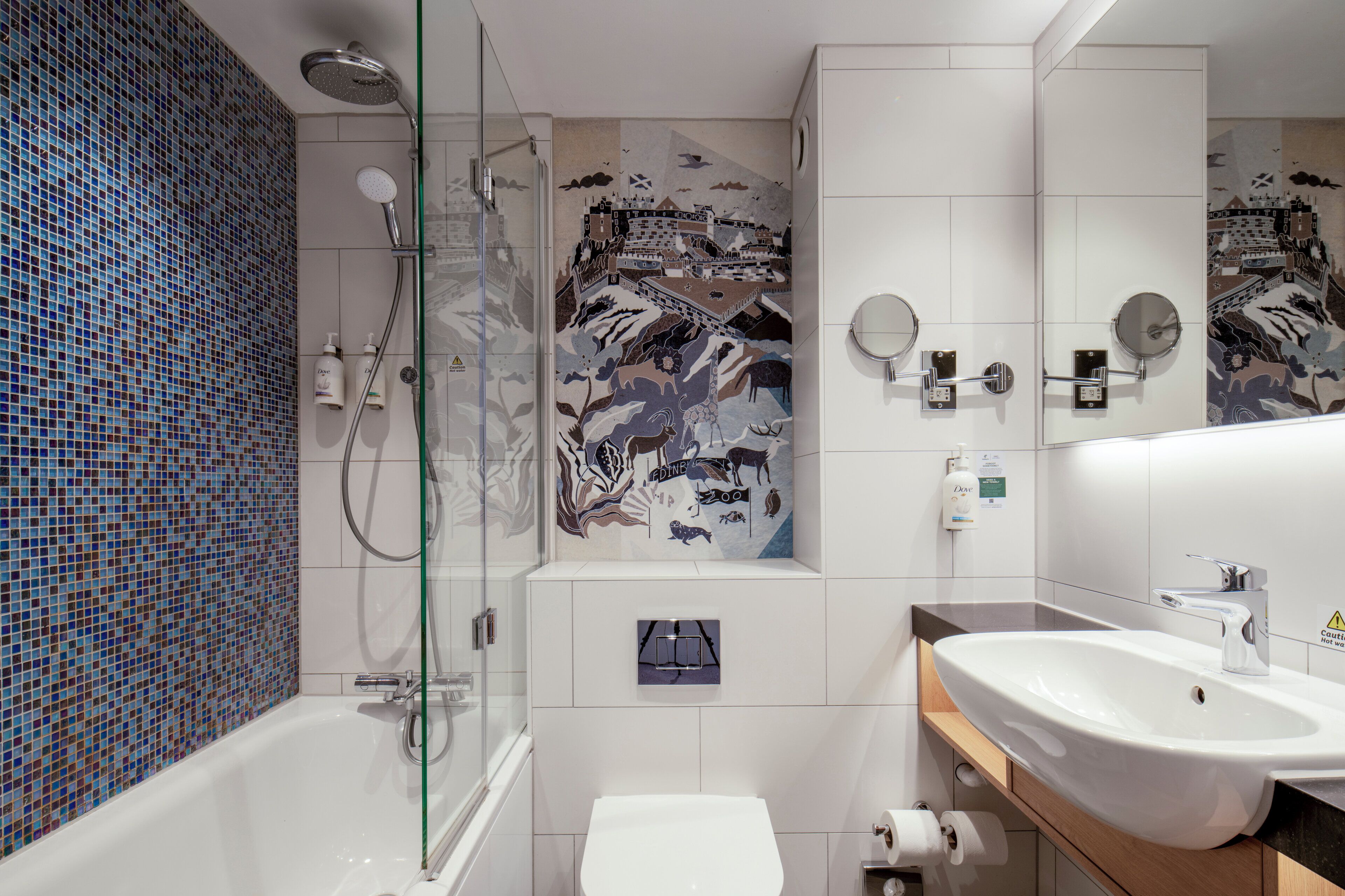A modern bathroom with a glass-enclosed shower, a white sink, and a toilet.