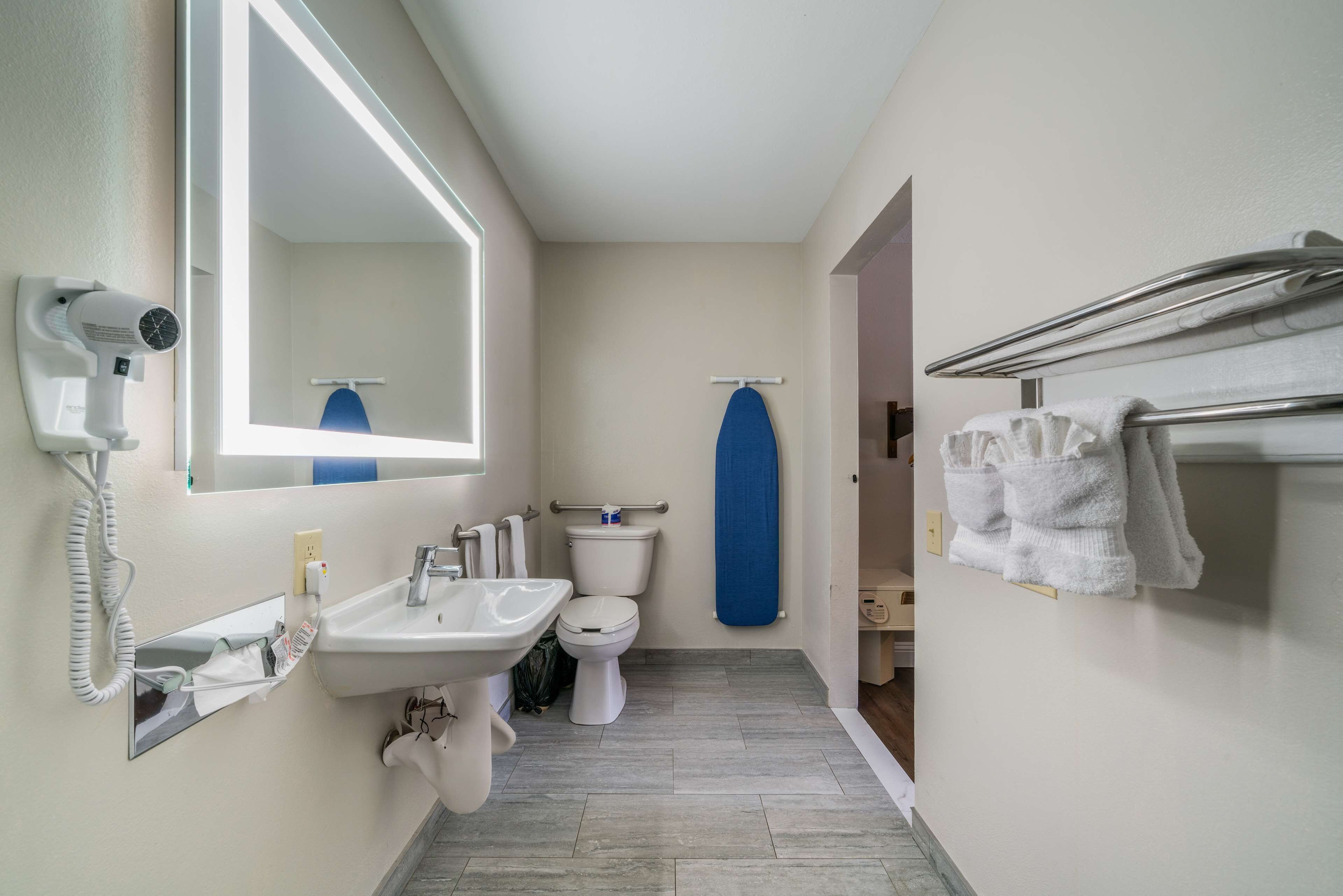 Un baño con lavabo, inodoro y espejo.