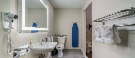 Un baño con lavabo, inodoro y espejo.