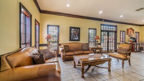 A spacious living room with leather sofas, a wooden coffee table, and a large window. - Best Western Inn Of Jasper (Jasper)