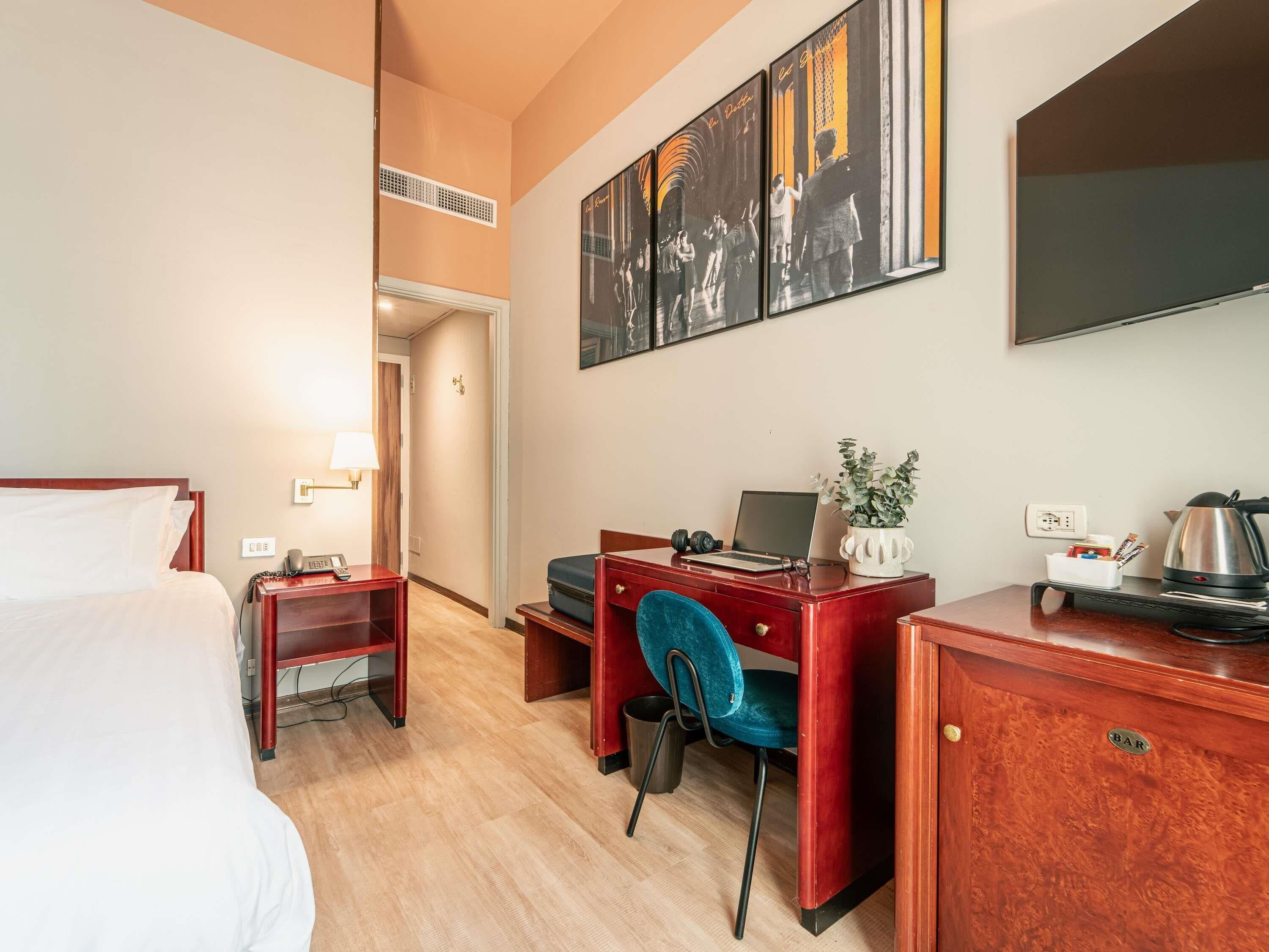 Une chambre d’hôtel équipée d’un lit, d’un bureau, d’une chaise et d’un téléviseur.