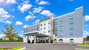 A modern hotel with a covered entrance, multiple floors, and a clear sky. - Holiday Inn Express & Suites Tampa Stadium – Airport Area by IHG (Tampa)