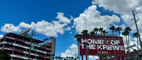 A stadium with a large red sign reading "Home of the Buccaneers" and "Advent Health".