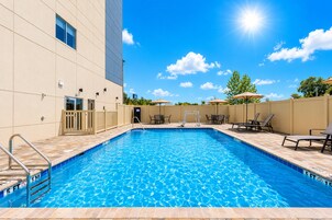 A swimming pool with a clear blue water surface, surrounded by a tiled deck.