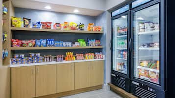 A snack and beverage display area with shelves stocked with various snacks and drinks, and two refrigerated display cases.