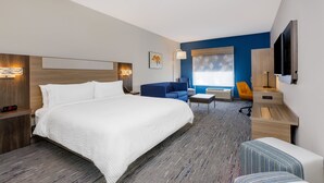 A modern hotel room with a large bed, a desk, a chair, and a TV. - Holiday Inn Express & Suites Tampa Stadium – Airport Area by IHG (Tampa)